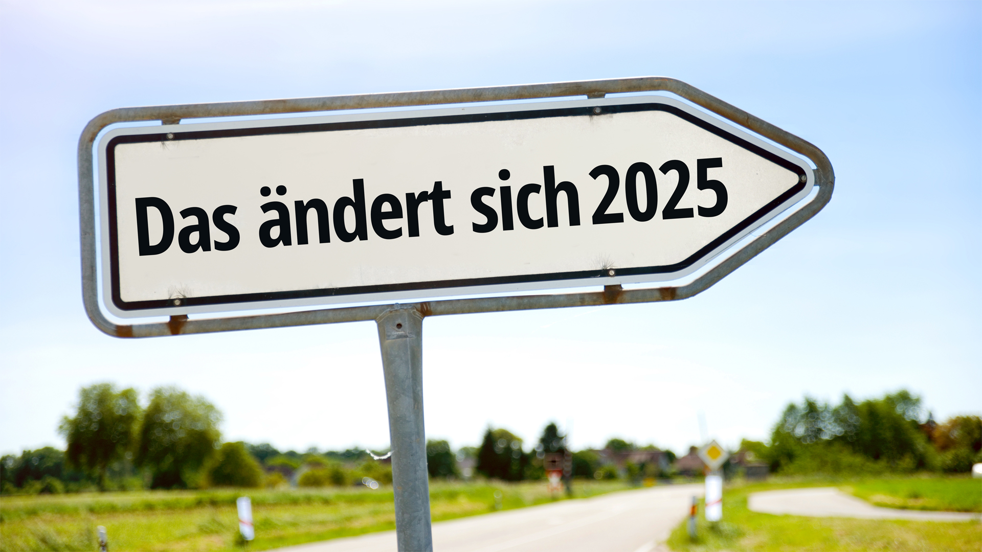 Wegweiser mit der Aufschrift “Das ändert sich 2025” vor einer grünen Landschaft und blauem Himmel, symbolisch für kommende Veränderungen.